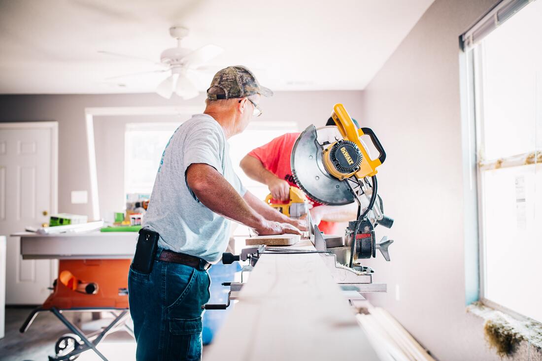 Nottingham Joinery craftsman cutting timber with a mitre saw in the workshop